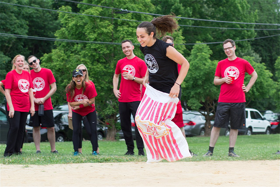 A member of the O3 World team jumping in a sack for the Sack Race event.